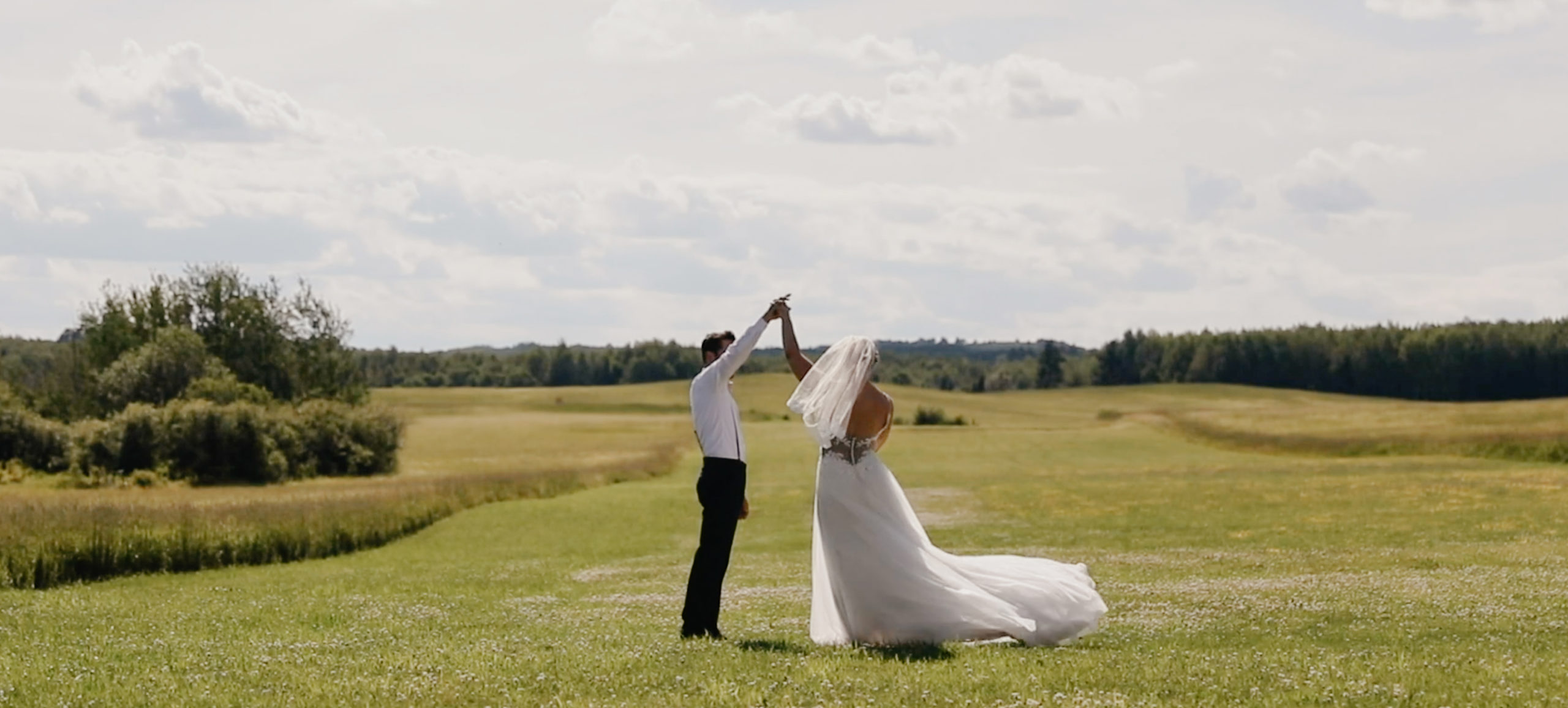 Bridal couple dancing in an open field