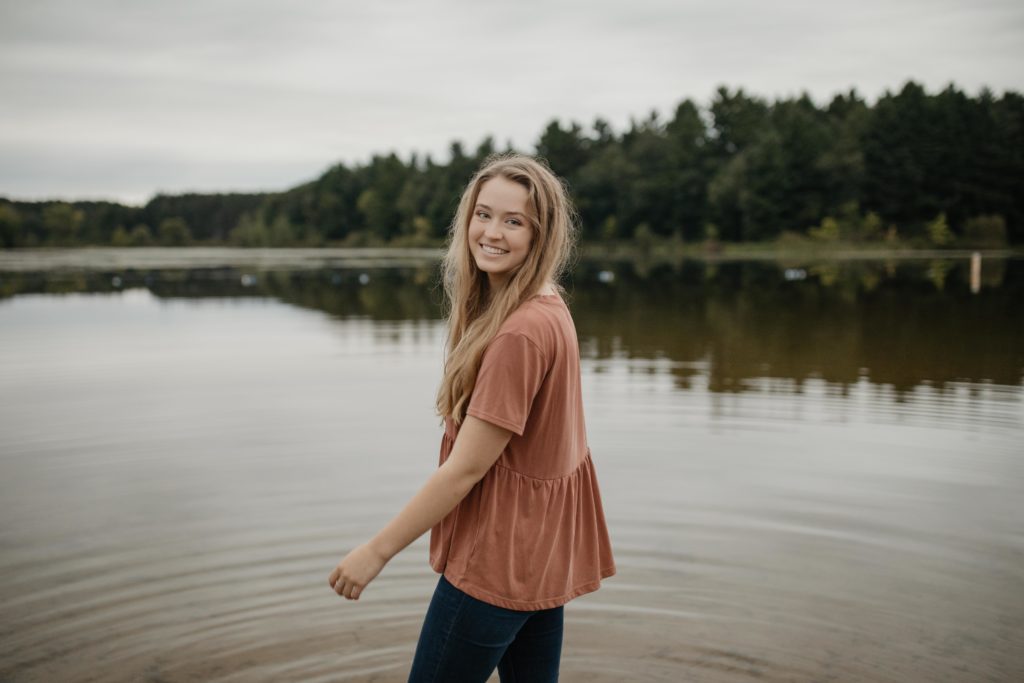 Girl smiling at the camera, standing in a lake